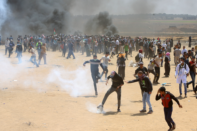 Palestinian protesters burn tires near the Israeli border fence, east of Khan Younis, in the Gaza Strip on May 14, 2018.